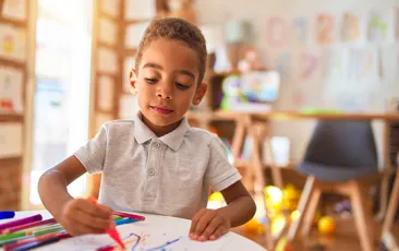 boy coloring in preschool