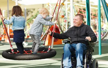 Man in wheelchair with children at the park