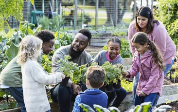 Teachers and young students in community garden