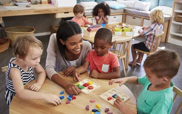 Preschool teacher with young students in classroom