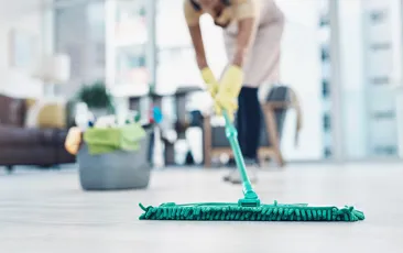 Domestic worker mopping the floor in nice apartment