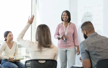 Image of teacher in classroom addressing other teachers in a training