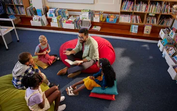 Teacher in library with young students