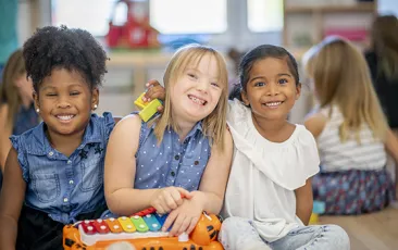 Young children hugging in a classroom