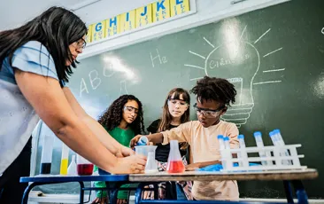 Elementary students working on science experiment with teacher