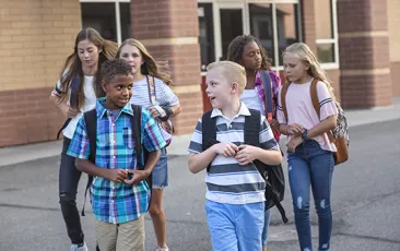 Happy kids leaving school building