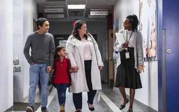 Principal with family in school hallway