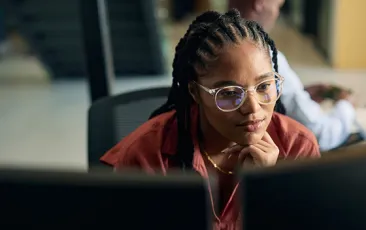 Thoughtful programmer working at her computer