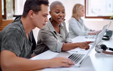 Community college student and teacher at computer