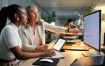 Older and younger colleagues working with data