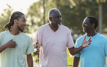 Three African American men walking and talking outside