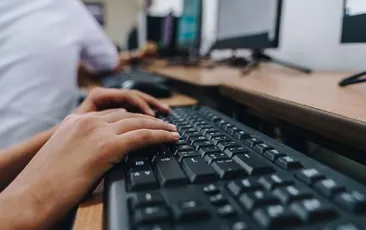 Hands at a computer keyboard