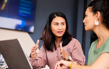 Two female colleagues discussing their work