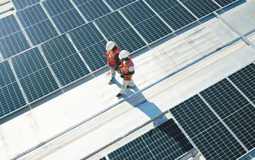 Workers on a roof with solar panels