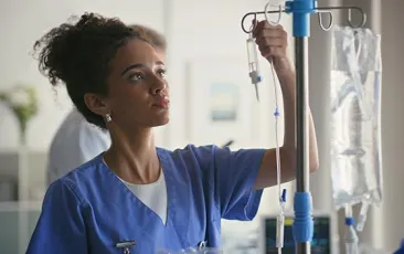 Young health care worker setting up an IV
