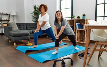Young woman with Down syndrome and her mother doing yoga