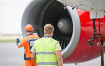 Airplane mechanics in front of an engine