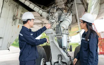 Airplane mechanics in front of an engine
