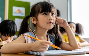 Elementary student with notebook in classroom