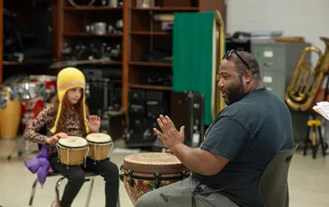 Teacher and student playing bongos