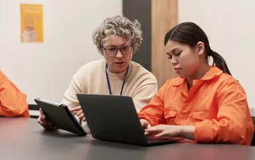 Teacher working with young woman in prison