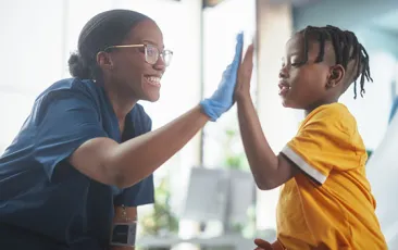 Kid high-fiving health care worker