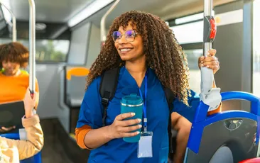 Young woman in scrubs commuting by subway