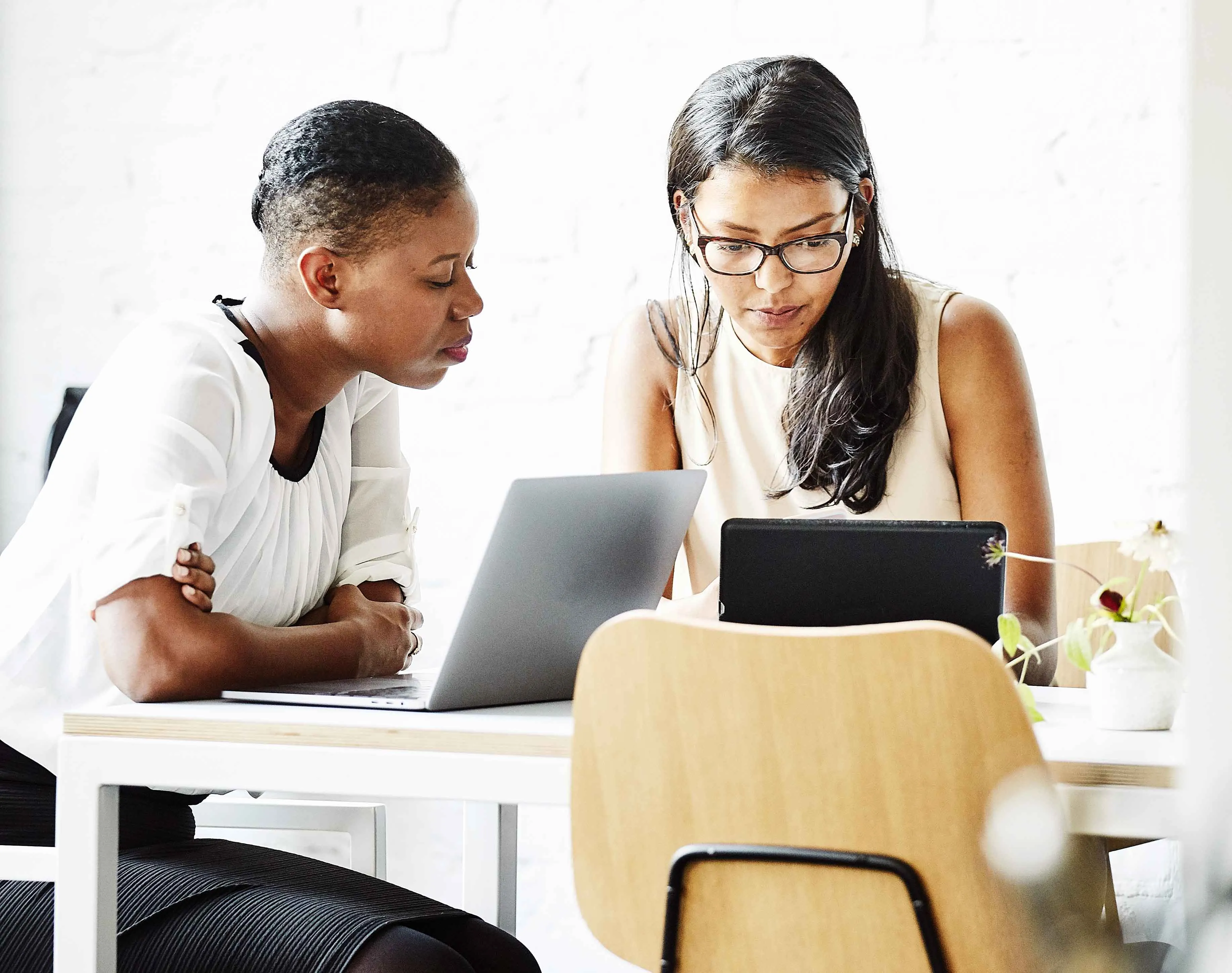 Two women working at laptops