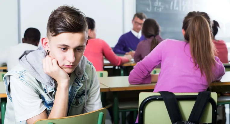 Sad teenager excluded in a classroom