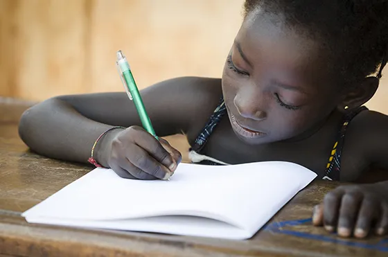 Young African girl writing in workbook