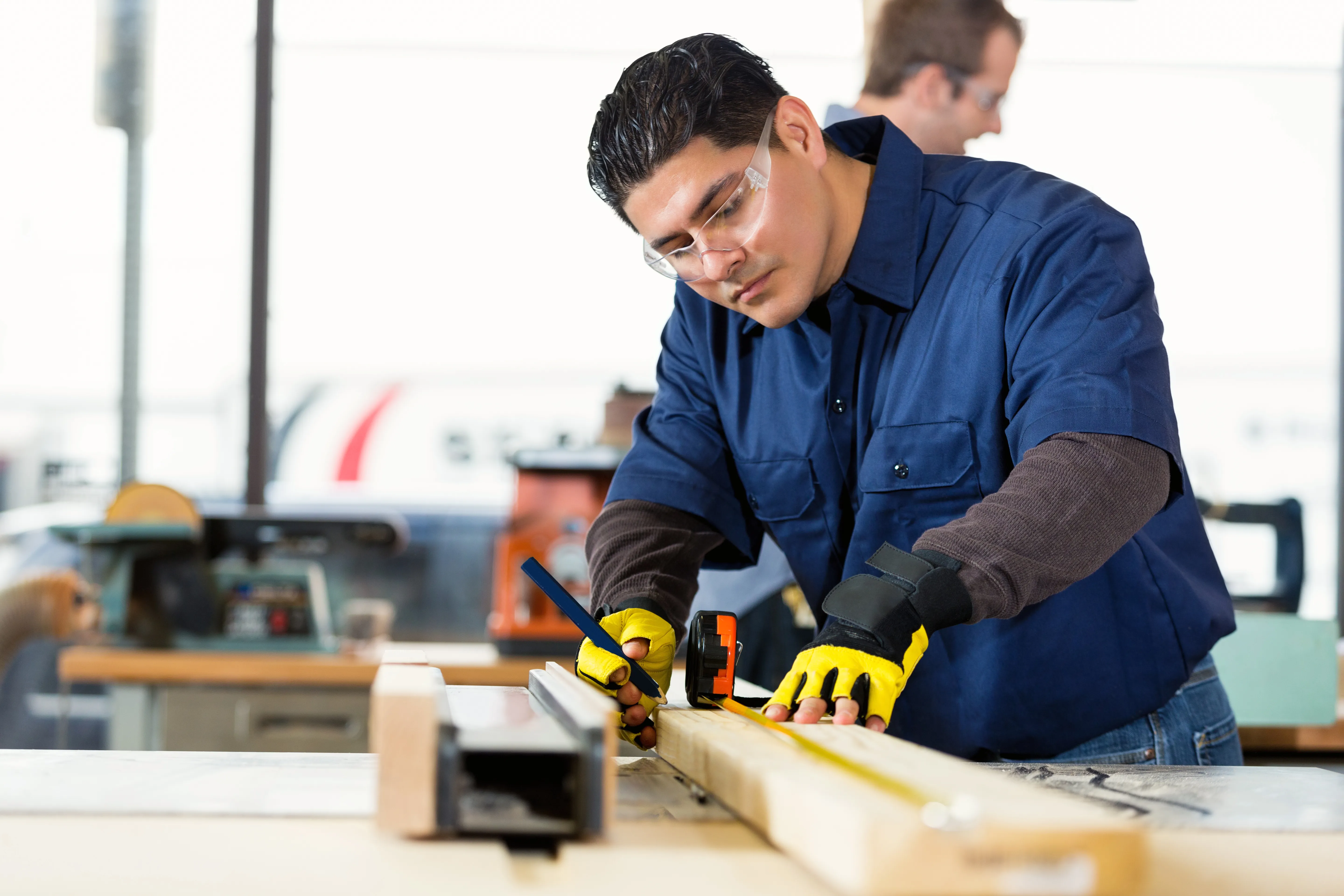 Male carpenter measuring a piece of wood