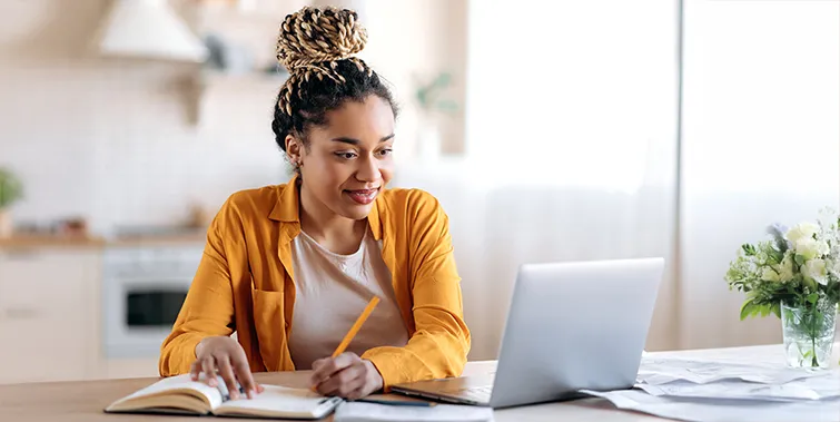 College student studying with laptop and notebook