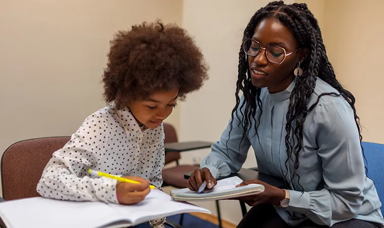 Teacher and student working together at desk