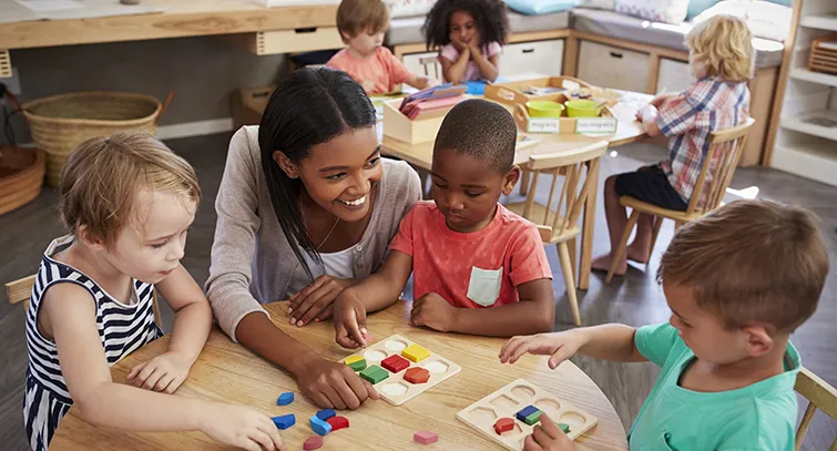 Preschool teacher with young students in classroom