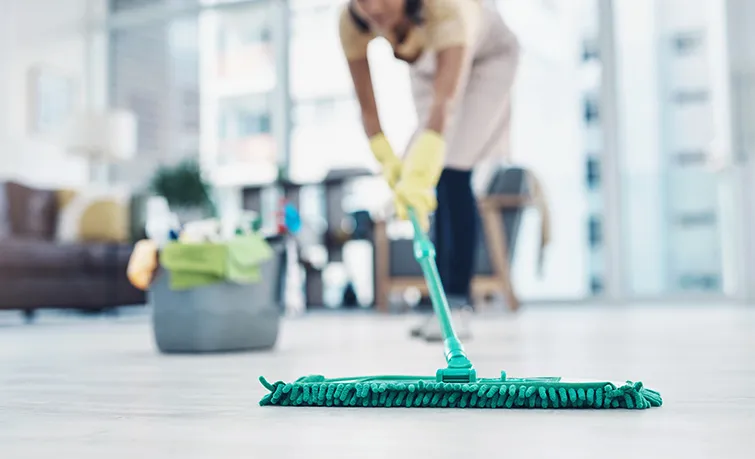 Domestic worker mopping the floor in nice apartment