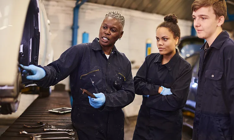 Trainer and apprentices in factory
