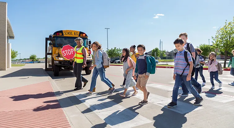 Students entering school with crossing guard