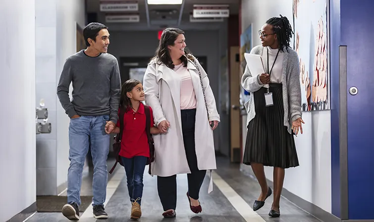 Principal with family in school hallway