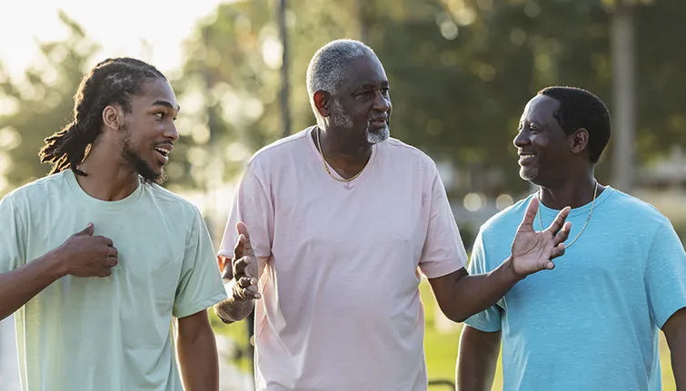 Three African American men walking and talking outside