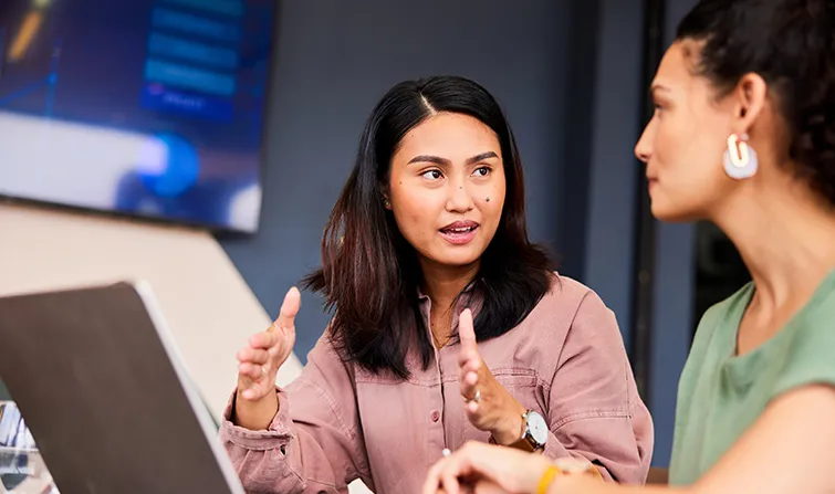 Two female colleagues discussing their work