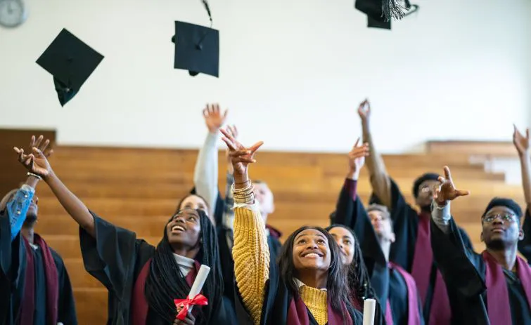 High school graduates throwing caps in the air