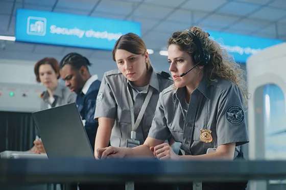 TSA workers at a laptop