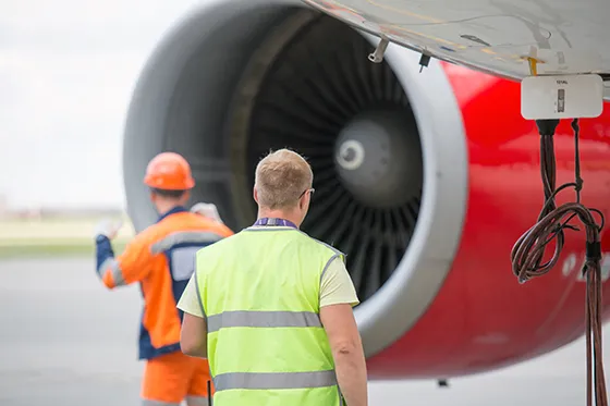 Airplane mechanics in front of an engine