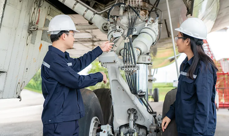 Airplane mechanics in front of an engine