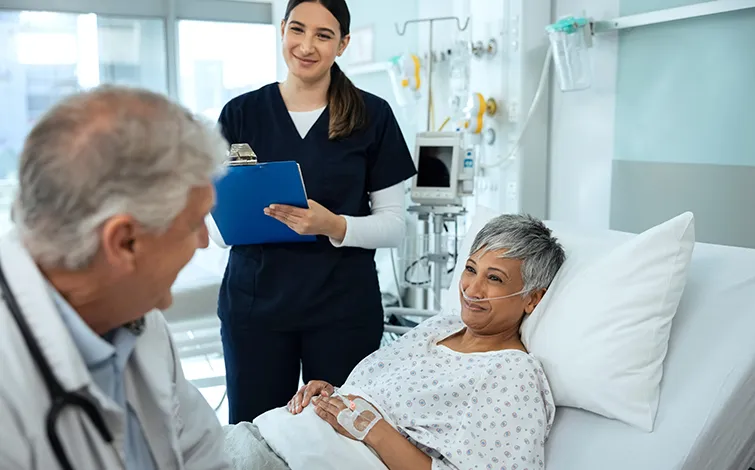 Provider and older patient in hospital bed