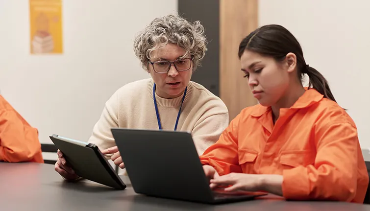 Teacher working with young woman in prison