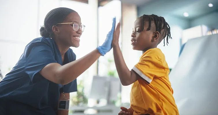 Kid high-fiving health care worker