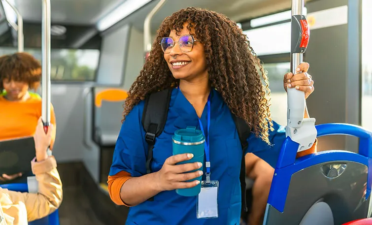 Young woman in scrubs commuting by subway
