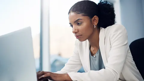 woman at work looking thoughtfully at computer