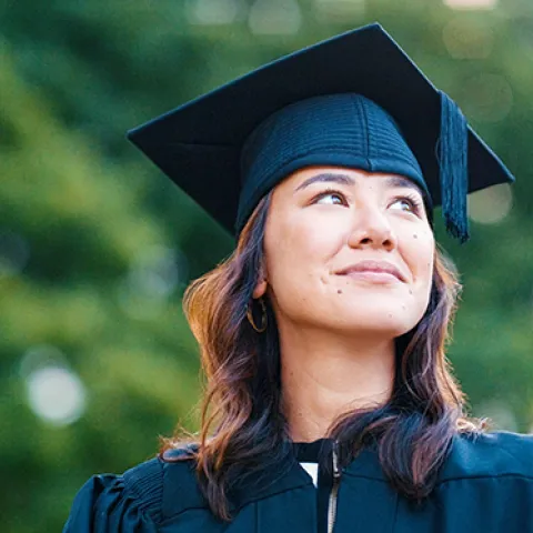 Young female college student in cap and gown